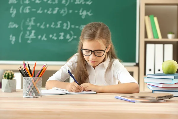 Little girl doing lessons in classroom — Stock Photo, Image