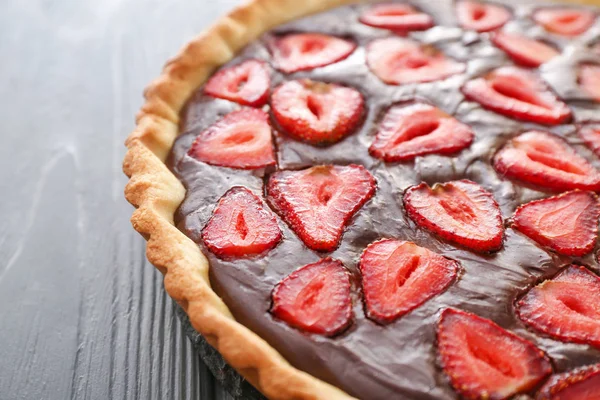 Gâteau au chocolat savoureux avec fraise sur la table, gros plan — Photo
