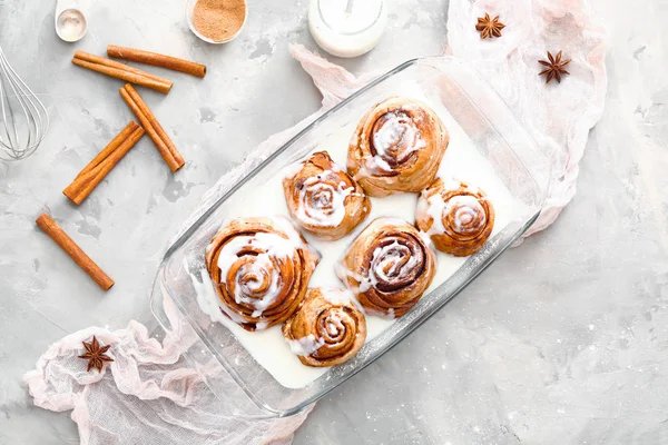 Baking tray with tasty cinnamon buns on grunge background — Stock Photo, Image