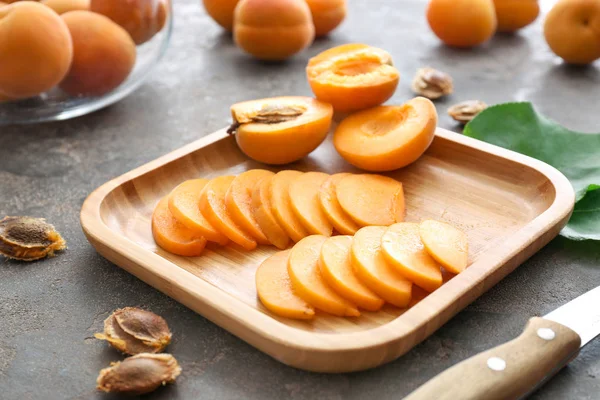 Plate with tasty cut apricots on table — Stock Photo, Image