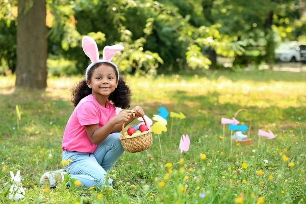 Kleine Afro-Amerikaanse meisje het verzamelen van paaseieren in Park — Stockfoto