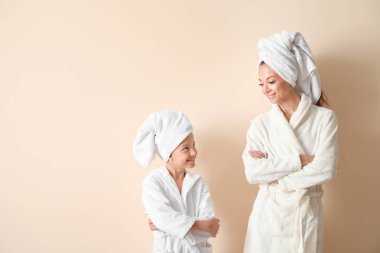 Hafif arka planda bornoz sevimli kızı ile mutlu anne Portresi