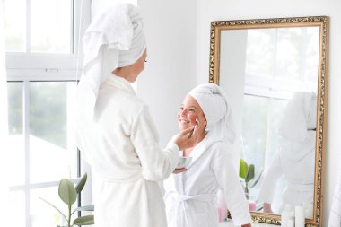 Banyoda kızının yüzüne maske uygulayan anne