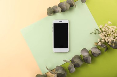 Renkli arka planda çiçek dekorlu modern cep telefonu