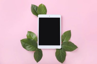 Renkli arka planda yeşil yapraklı modern tablet bilgisayar