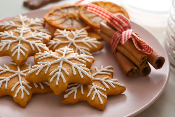 Plate with tasty Christmas cookies and cinnamon on table, closeup — Stock Photo, Image