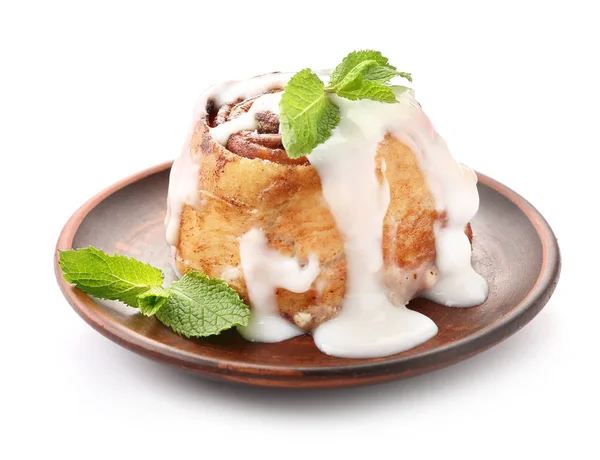 Тарелка с вкусной булочкой корицы на белом фоне — стоковое фото