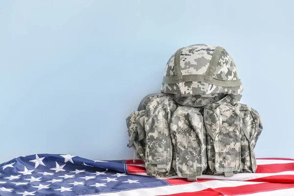Military helmet, vest and USA flag on table