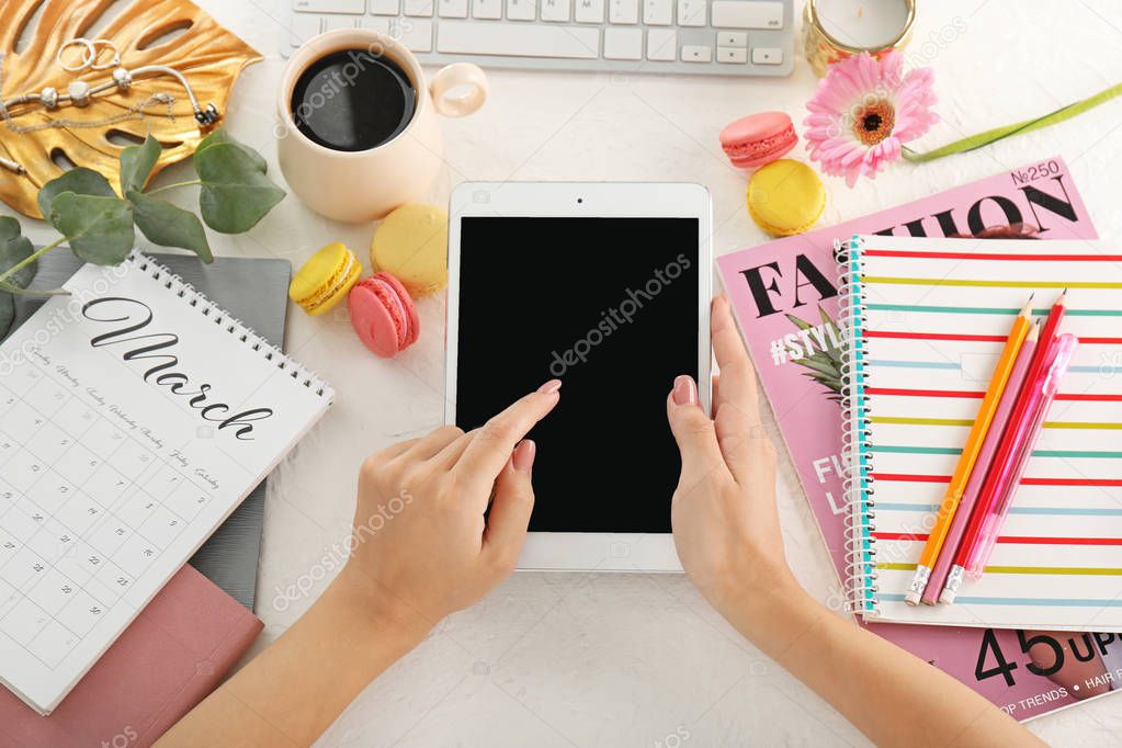 Woman with tablet computer at white table