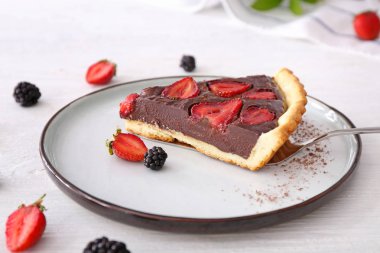 Beyaz masada lezzetli çikolatalı çilekli kek parçası ile Tabak