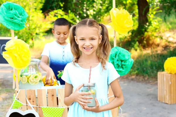 Niedliche kleine Kinder in der Nähe von Limonadenstand im Park — Stockfoto