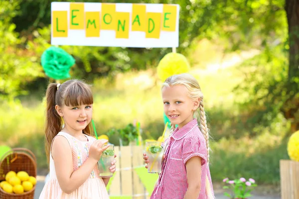 Süße kleine Mädchen trinken Limonade im Park — Stockfoto