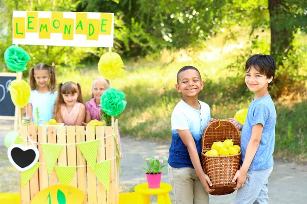 Lindos niños pequeños vendiendo limonada en el parque — Foto de Stock