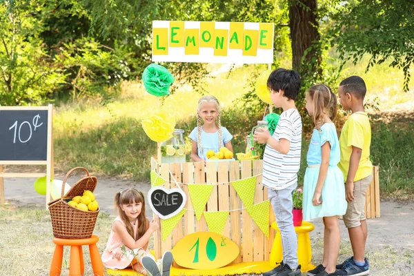 Linda niña vendiendo limonada en el parque — Foto de Stock