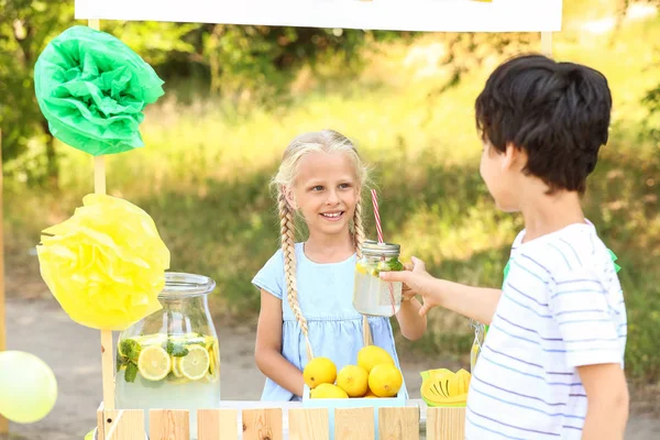 귀여운 소녀가 공원에서 레모네이드를 파는 모습 — 스톡 사진