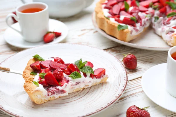 Assiette avec morceau de gâteau aux fraises savoureux sur la table — Photo