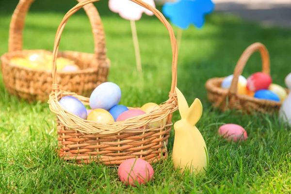 Basket with Easter eggs and bunny on grass outdoors — Stock Photo, Image