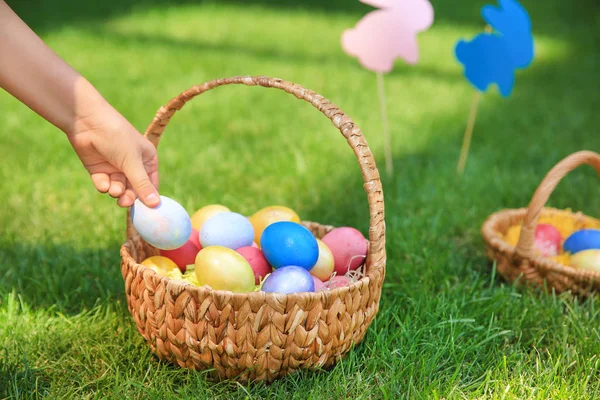 Woman gathering Easter eggs outdoors — Stock Photo, Image