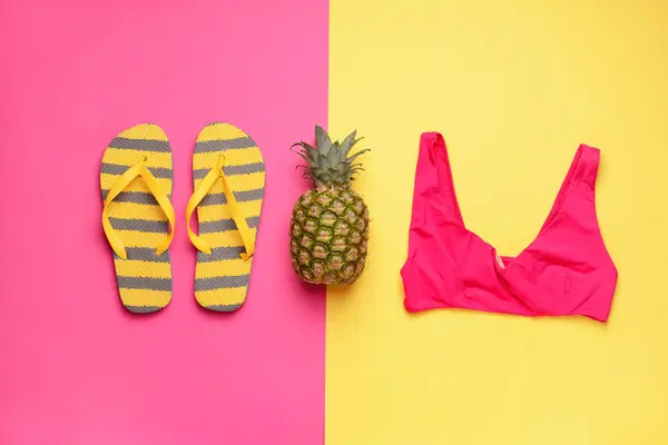 Flip-flops, swimming suit and pineapple on color background — Stock Photo, Image