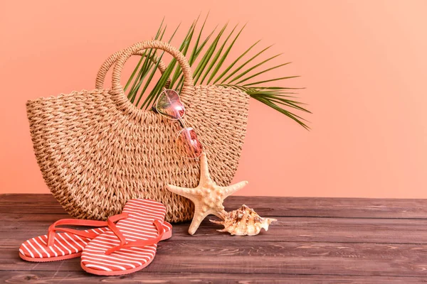 Bolsa de playa y accesorios en la mesa contra el fondo de color —  Fotos de Stock