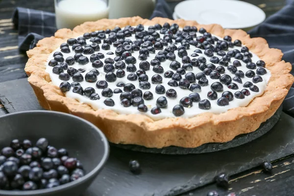 Tasty bilberry pie on table