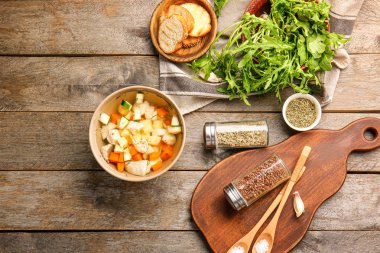 Ahşap masada ekmek ve baharat ile lezzetli çorba Kase