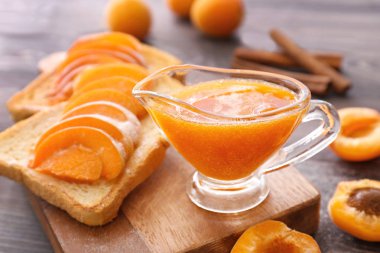 Ahşap tahta üzerinde lezzetli kayısı reçeli ile ekmek dilimleri
