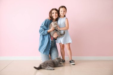 Renkli duvara yakın sevimli kediler ile Mutlu anne ve kızı