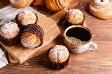 Ahşap masada kahve fincanı ile lezzetli kekler