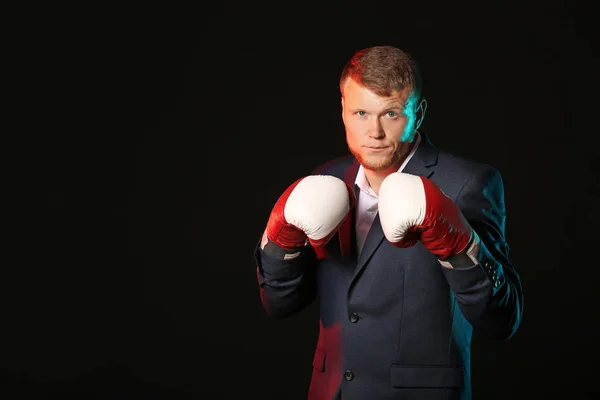 Empresario en guantes de boxeo sobre fondo oscuro — Foto de Stock