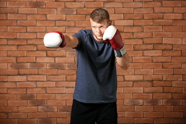 Boxeador masculino fuerte contra la pared de ladrillo — Foto de Stock