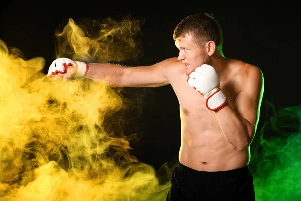 Boxeador masculino fuerte en humo sobre fondo oscuro — Foto de Stock