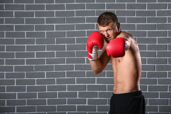 Strong male boxer against brick wall — Stock Photo, Image