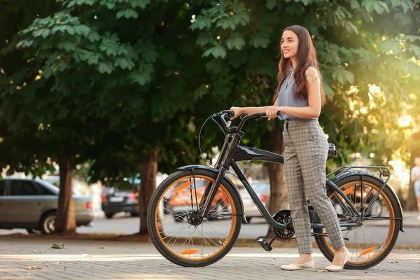 Young woman with bicycle outdoors — Stock Photo, Image