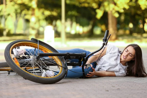 Mladá žena spadla z kola venku — Stock fotografie