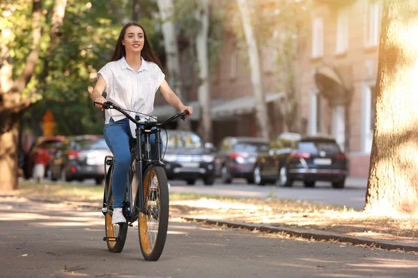 Young woman riding bicycle outdoors — Stock Photo, Image