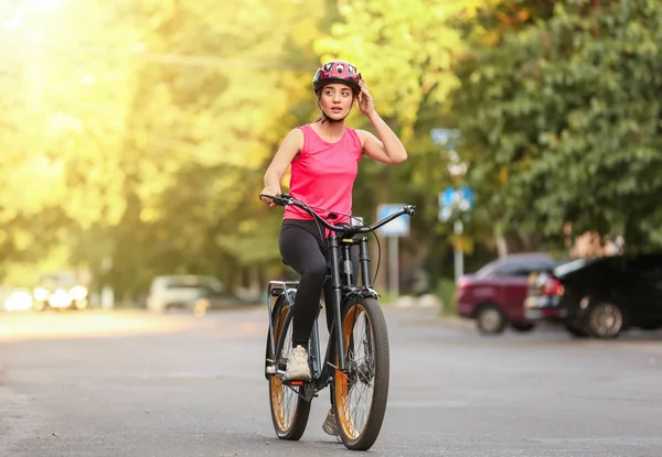 Sporty young woman riding bicycle outdoors — Stock Photo, Image