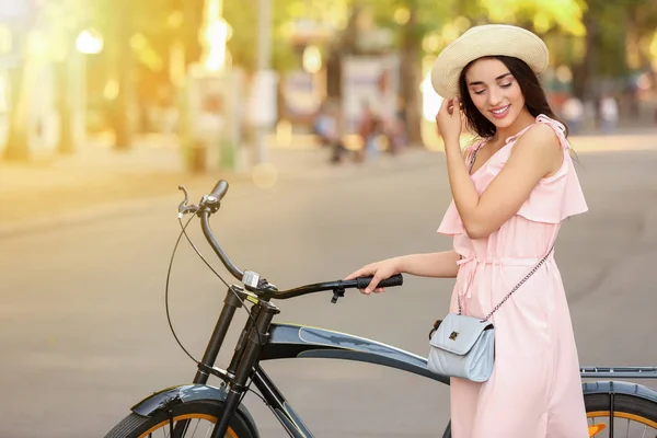 Beautiful young woman with bicycle outdoors — Stock Photo, Image