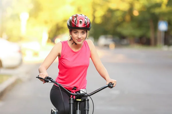 Sporty young woman riding bicycle outdoors — Stock Photo, Image