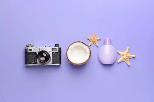 Fotocamera, profumo, cocco e stelle marine su sfondo a colori — Foto Stock