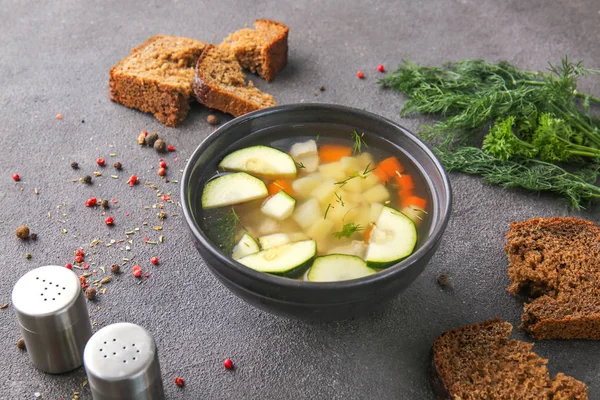 Cuenco de sabrosa sopa con pan y especias sobre fondo gris — Foto de Stock