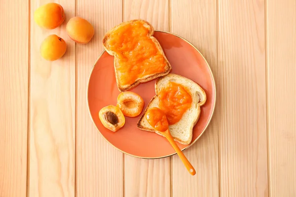 Bord met lekkere brood schijfjes en confituur op houten tafel — Stockfoto