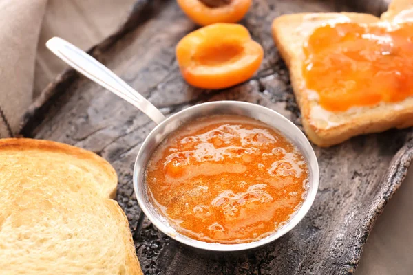 Tasty apricot jam and bread slices on plate, closeup — Stock Photo, Image