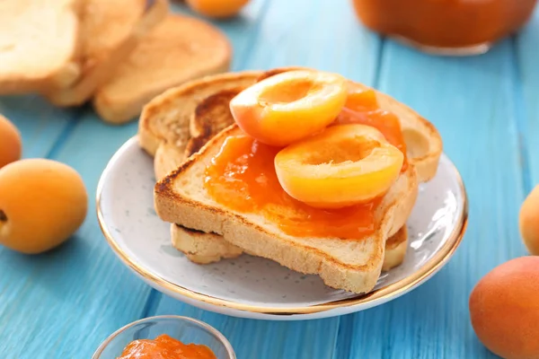 Хлебные ломтики вкусного абрикосового варенья на деревянном столе — стоковое фото