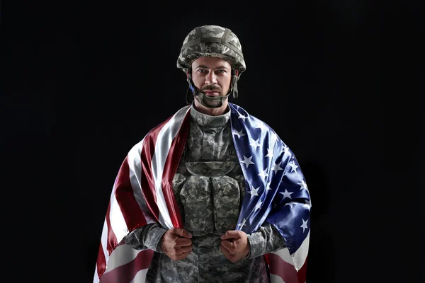 Soldier with national flag of USA on dark background — Stock Photo, Image