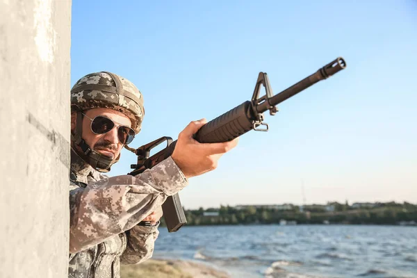 Soldado en camuflaje apuntando en emboscada al aire libre — Foto de Stock