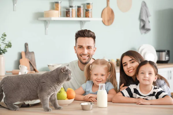 Familia feliz con gato lindo en la cocina — Foto de Stock