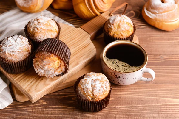 Ahşap masada kahve fincanı ile lezzetli kekler