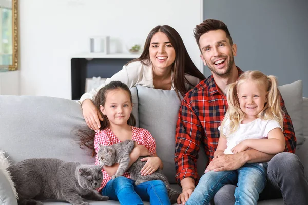 Happy family with cute cats resting at home — Stock Photo, Image