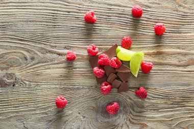Ahşap masada çikolata ve kireç ile taze ahududu
